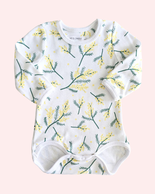 Baby onesie with floral wattle pattern on a pink background