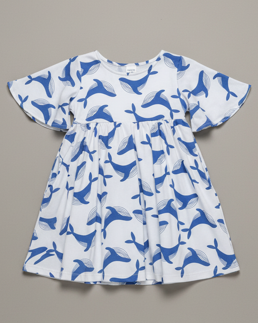 image of the blue whale dress flat-lay on a grey background. A professional studio shoot with a 35mm camera shot at an elevated angle. bright lighting reflecting a premium professinoal product shoot. Highlight the flared sleeves, f
