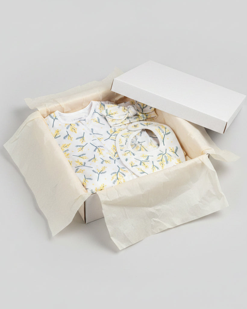 Newborn baby wrapped in pink whale organic cotton blanket, showcasing its softness and versatile use.