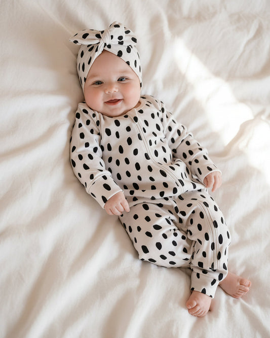 Baby wearing the black cheetah print organic bodysuit on a textured blanket with soft natural light, highlighting fabric details and comfort.