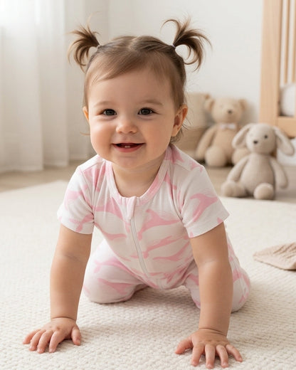 Toddler girl wearing pink whale romper with pigtails in nursery, focus on the textured organic cotton fabric and whale print, softly lit scene.