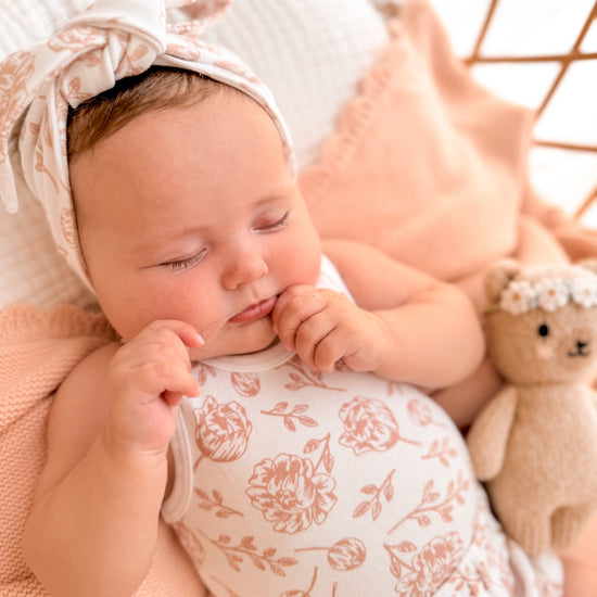 Newborn baby sleeping peacefully in matching clothing set
