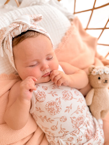 Newborn baby sleeping peacefully in matching clothing set
